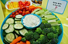 a platter filled with cucumbers, carrots, broccoli and other veggies