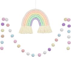 a rainbow decoration with tassels hanging from it's sides and balls on the ground