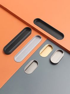 an orange and grey surface with three different metal objects on the top one is empty