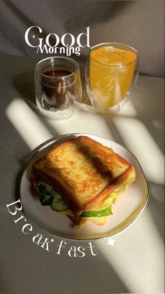 a sandwich on a plate next to a glass of orange juice