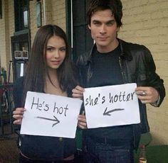 two people holding signs that say he's hot and she's not