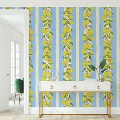 a wallpapered room with yellow flowers on blue and white striped walls, a console table in the foreground