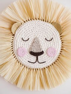 a crocheted lion's face on top of a white wall hanging decoration