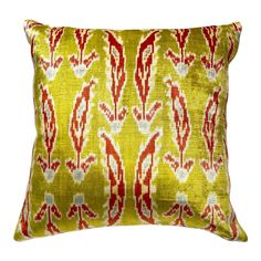 a yellow pillow with red and white designs on it