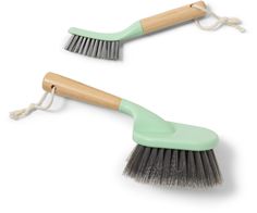 two green brushes with wooden handles on white background for use in cleaning products or as decoration