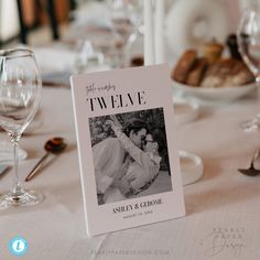 a table with wine glasses, plates and silverware is set up for a wedding reception