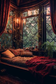 a bed sitting in front of a window next to a plant