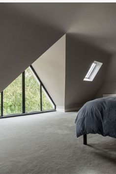 an attic bedroom with slanted ceilings and large windows