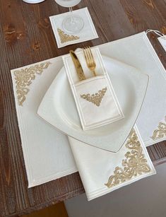 the place setting is ready to be served on the dining room table, with gold trimmings