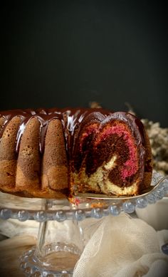 a bundt cake with chocolate icing on a glass platter