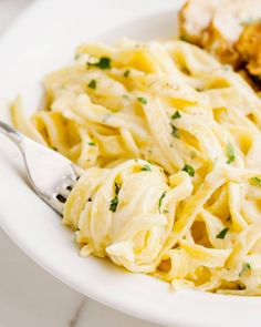 a white plate topped with pasta and chicken