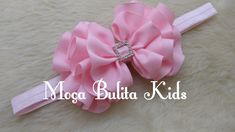 a pink headband with a large bow on it and the words moga bulla kids