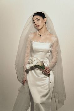 a woman in a white wedding gown and veil