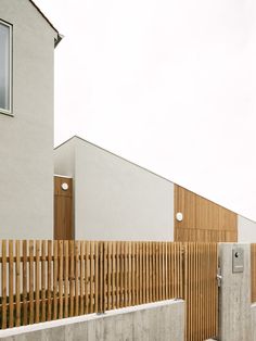 a wooden fence next to a white building