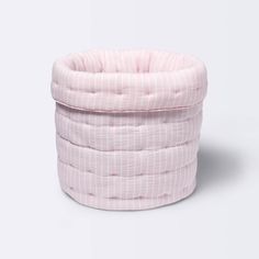 the pink and white striped baby bed is folded up on top of it's head