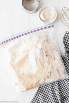 the ingredients for making an easy cake are laid out on a white counter top, including flour, eggs and butter