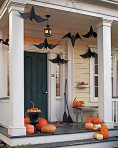 a porch decorated for halloween with pumpkins and bats