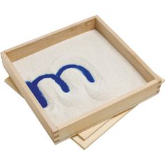 two wooden trays with sand and blue writing on them, one is made out of wood