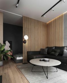 a modern living room with black leather furniture and wood slats on the wall behind it