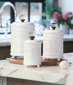 three white canisters sitting on top of a counter