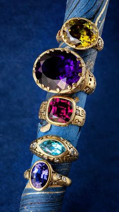 an assortment of rings sitting on top of a blue cloth