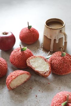 several pieces of fruit sitting on top of a counter next to an apple and a cup