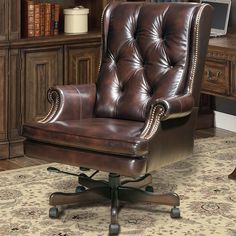 a brown leather office chair sitting in front of a book shelf with books on it