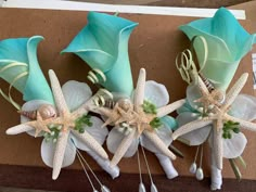 three starfish boutions with seashells and flowers