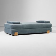 a blue couch sitting on top of a white floor