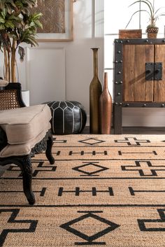 a living room area with a rug, chair and vases