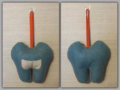 the toothbrush holder is made out of felt and has an orange toothpick on it