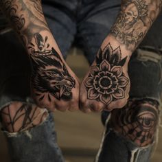 two hands with tattoos holding each other