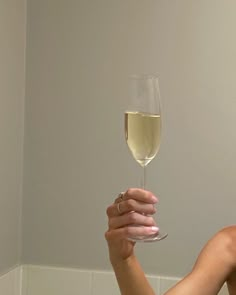 a woman holding a wine glass in her hand