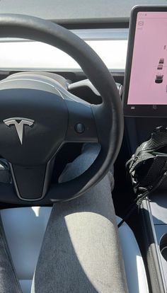 the interior of a car with a laptop and steering wheel