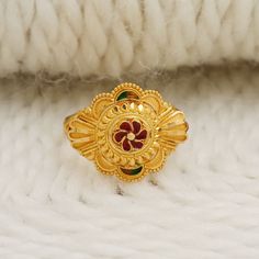 a close up of a gold ring on a white surface