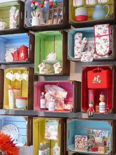 a shelf filled with lots of different colored boxes and containers on top of each other