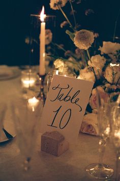 a table is set up with candles and place cards for the guests to sit at