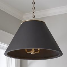 a black lamp hanging from a ceiling in a room with white walls and trimmings