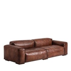 a brown leather couch sitting on top of a white wall