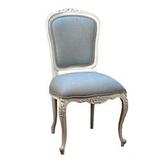 an antique chair with a blue upholstered back and white trim around the seat