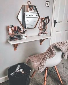 a white desk topped with a mirror next to a chair