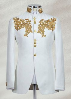 a white and gold jacket on a mannequin stand with an embroidered coat over it