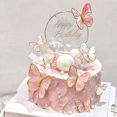 a pink and gold birthday cake with butterflies on it