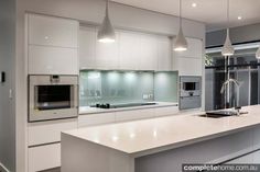 a modern kitchen with white cabinets and stainless steel appliance in the island area