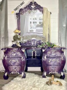 a purple dresser sitting in front of a mirror on top of a white carpeted floor