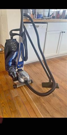 a vacuum is sitting on the floor in front of a kitchen