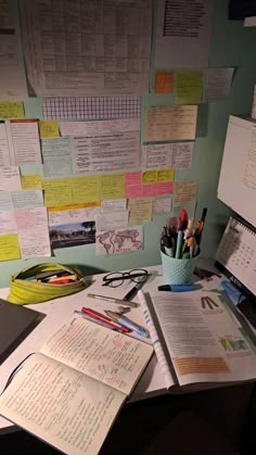 a desk with many papers and pens on it