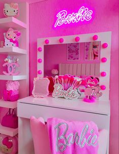 a pink room with hello kitty decorations and lights on the wall, including a vanity