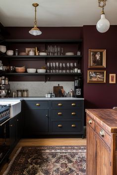 a kitchen with black cabinets and gold pulls on the cupboards is pictured in this image