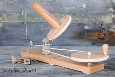 a wooden model of a record player on a table with tools around it and an object in the foreground